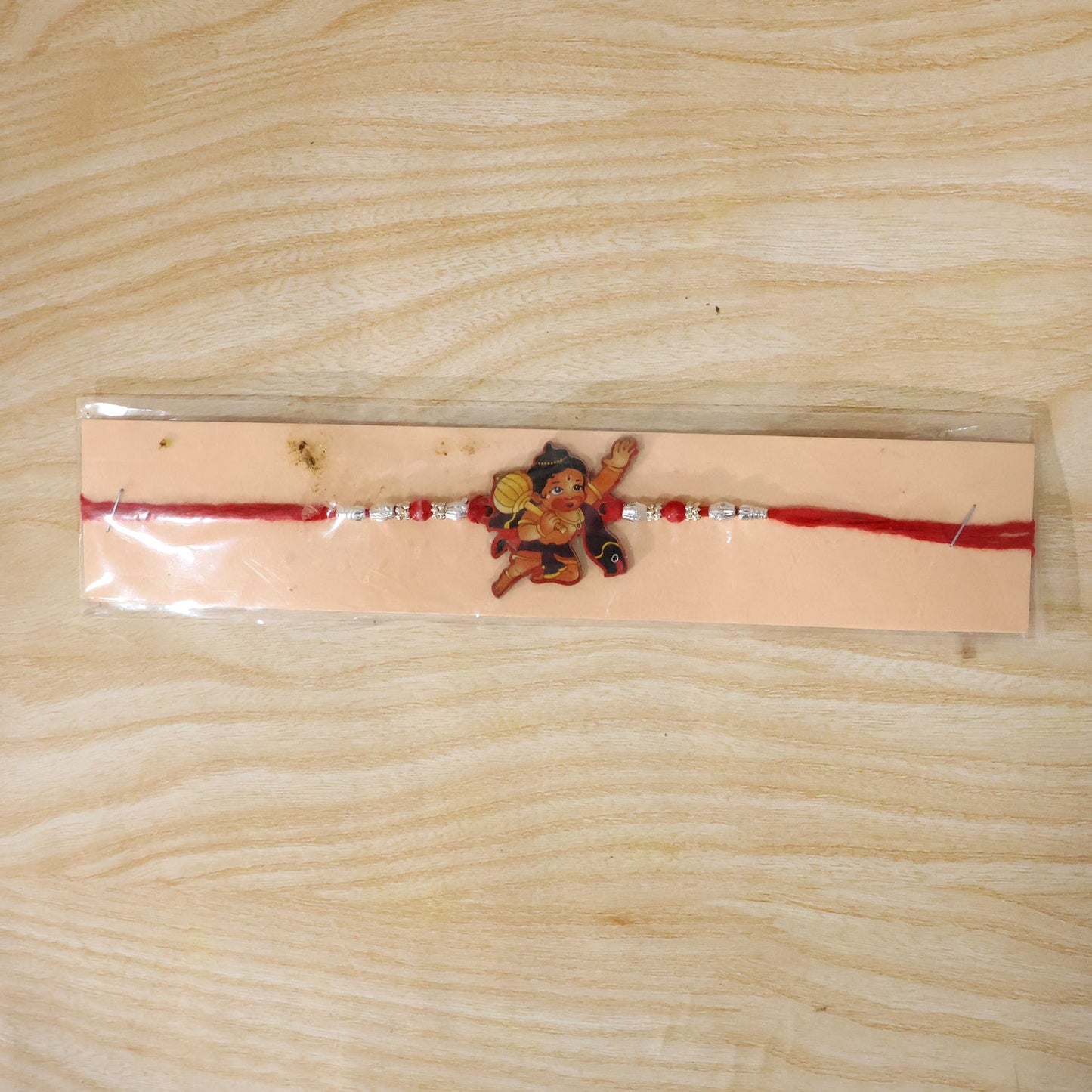 Festive Hanuman Rakhi with beaded accents and red thread