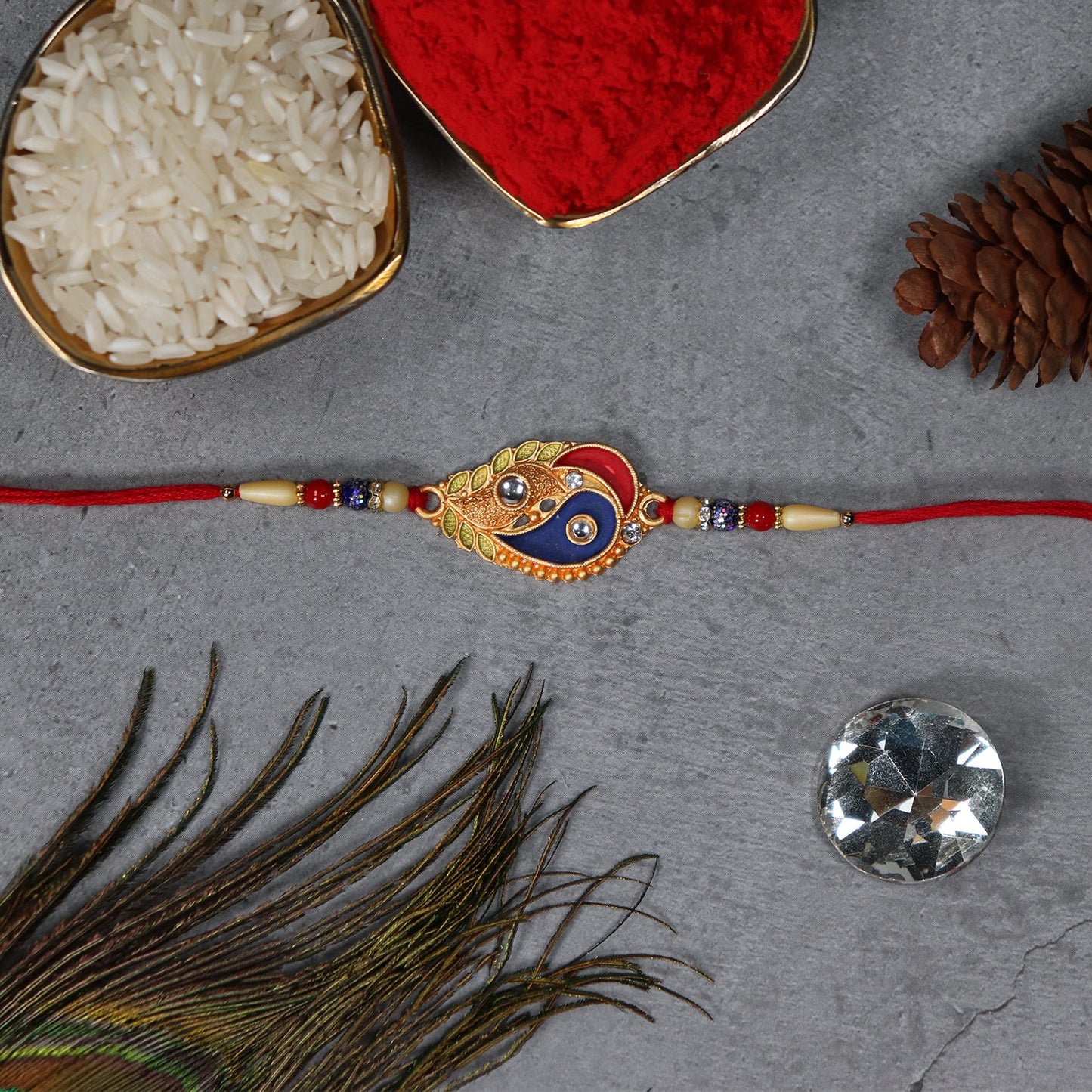 Elegant enamel paisley rakhi with gold-tone embellishments perfect for Raksha Bandhan