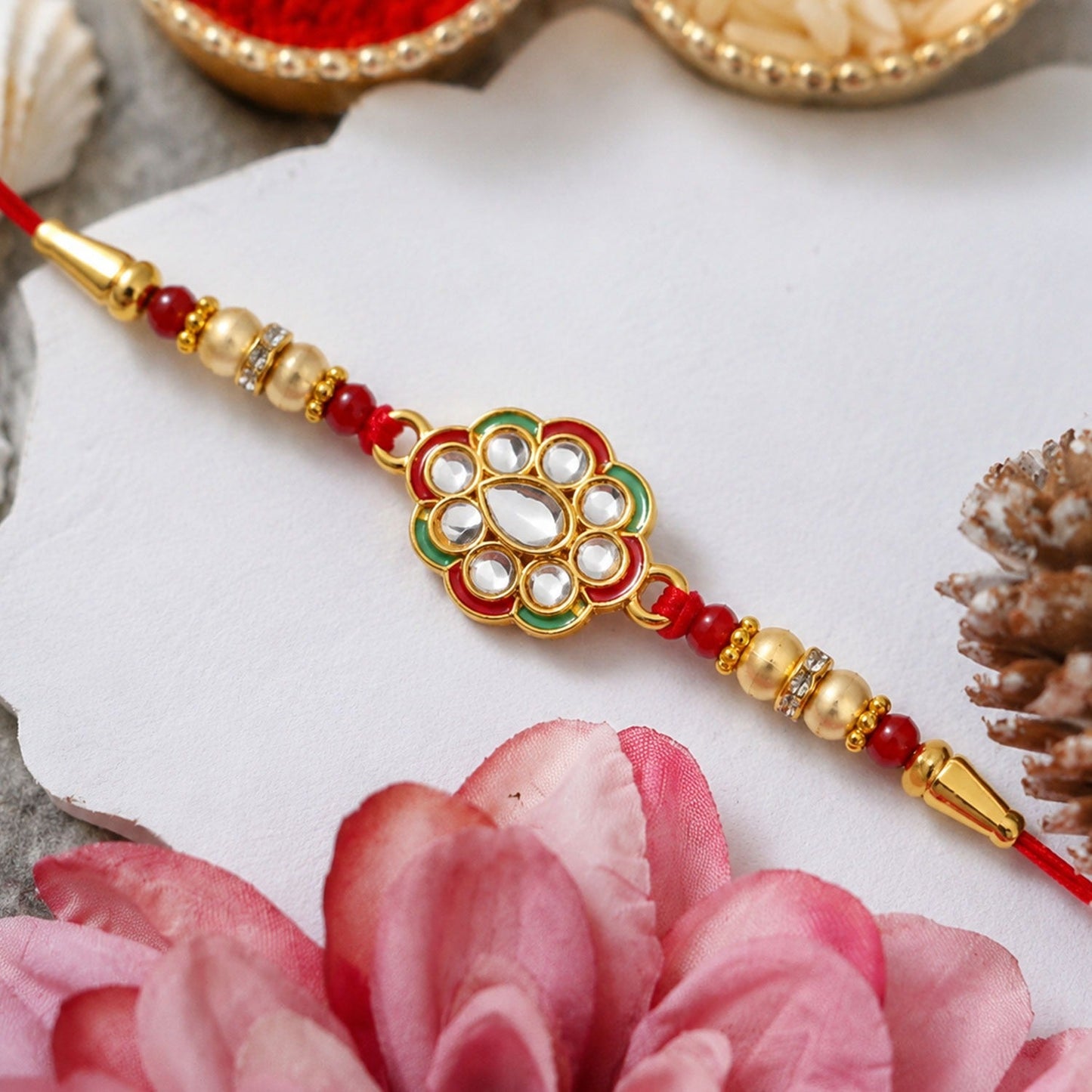 Front view of Kundan Work Floral Rakhi with red thread symbolizing traditional Raksha Bandhan gift