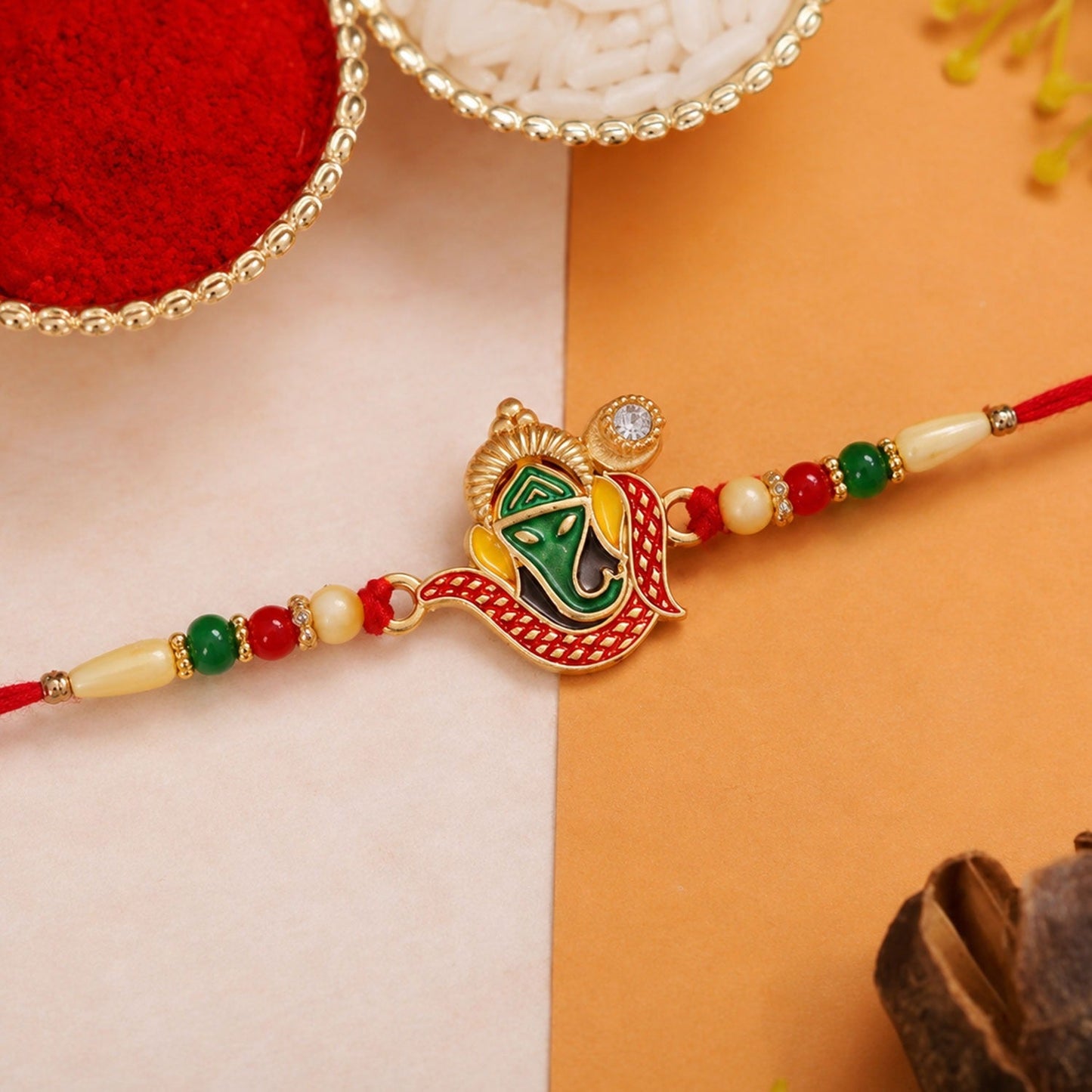 Elegant Ganpati Rakhi with vibrant red and green beads for Raksha Bandhan