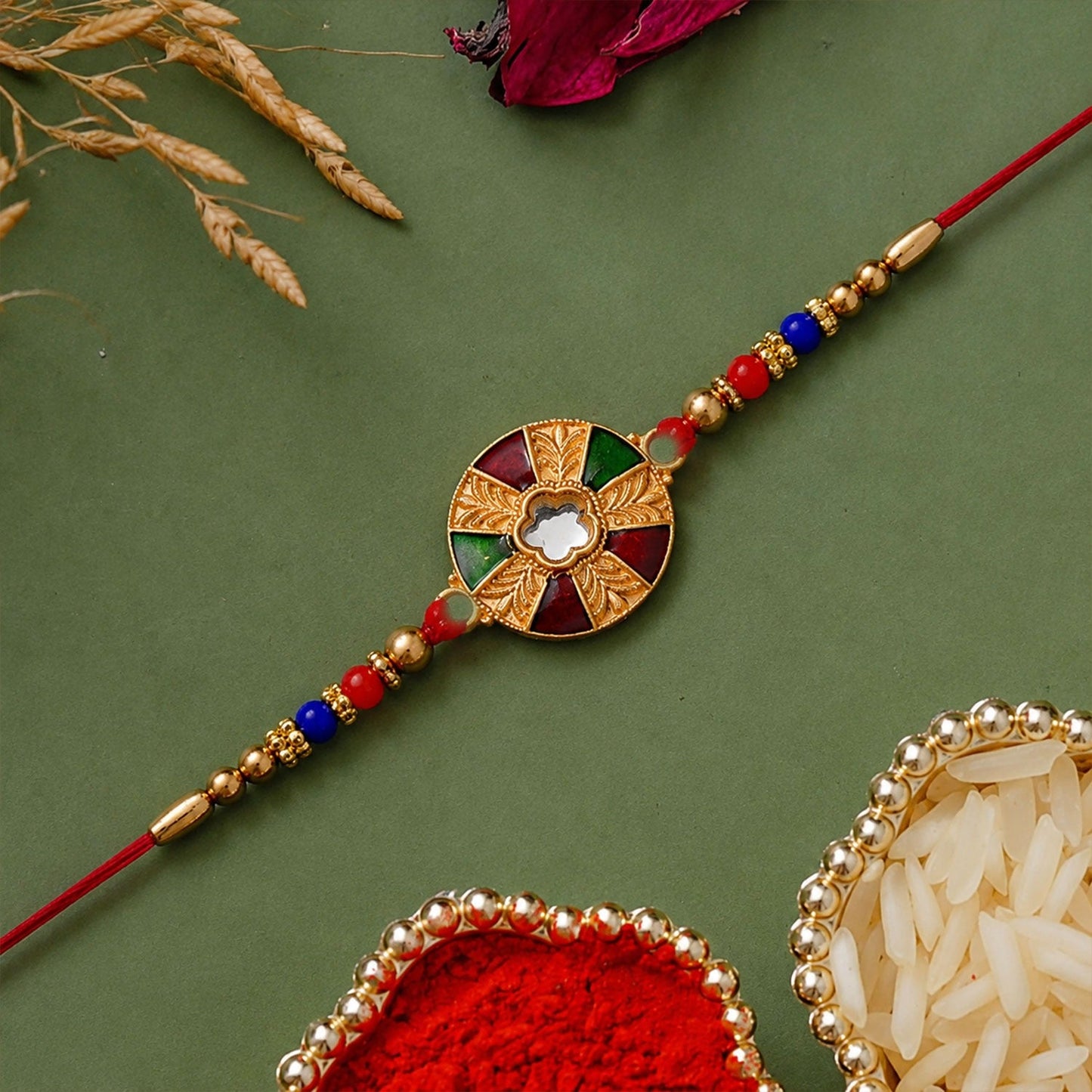 Multicolor kundan rakhi with golden floral round dial and beaded red thread