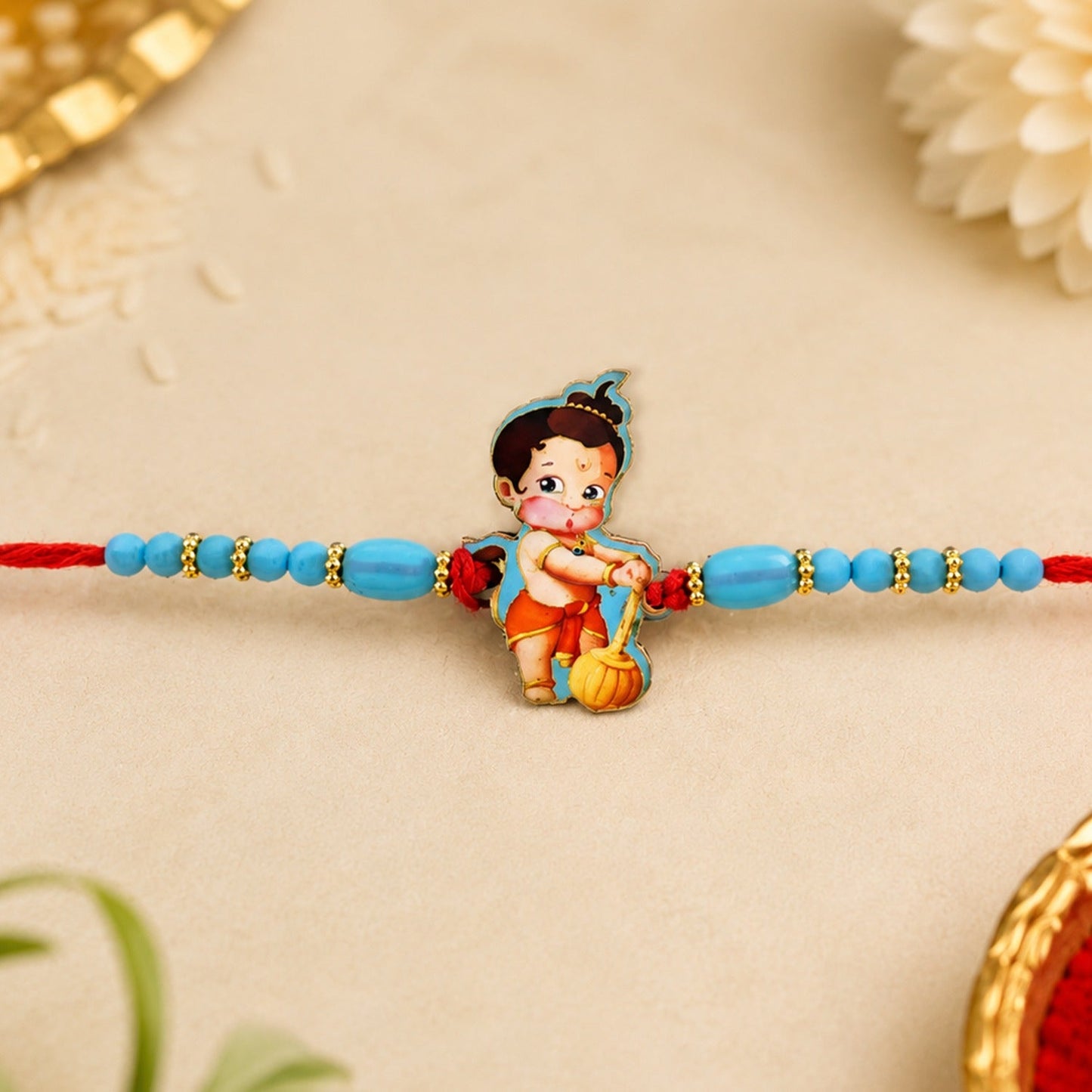 Vibrant Hanuman kids Rakhi with blue beads and red thread, perfect for Raksha Bandhan.