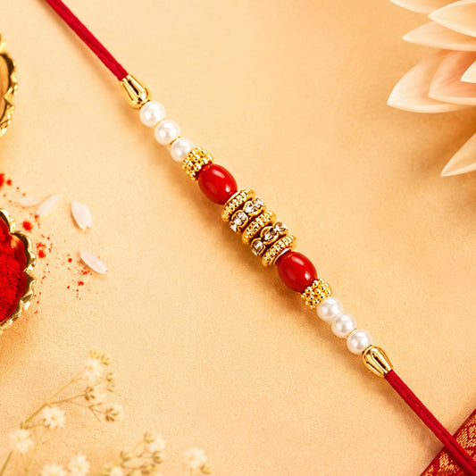 Pearl Beaded Rakhi with red beads and golden accents for Raksha Bandhan celebration.