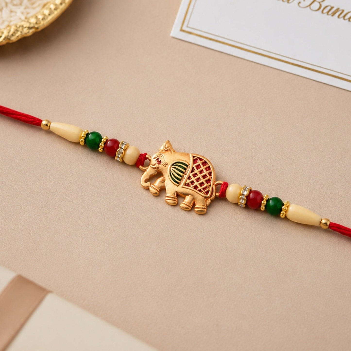 Close-up of a vibrant Elephant Rakhi with intricate traditional design and colourful threads.