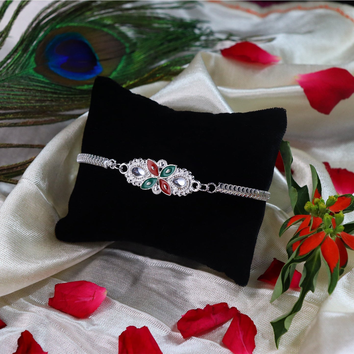 Red green enamel Floral Rakhi delicately tied on a brother's wrist for Raksha Bandhan.