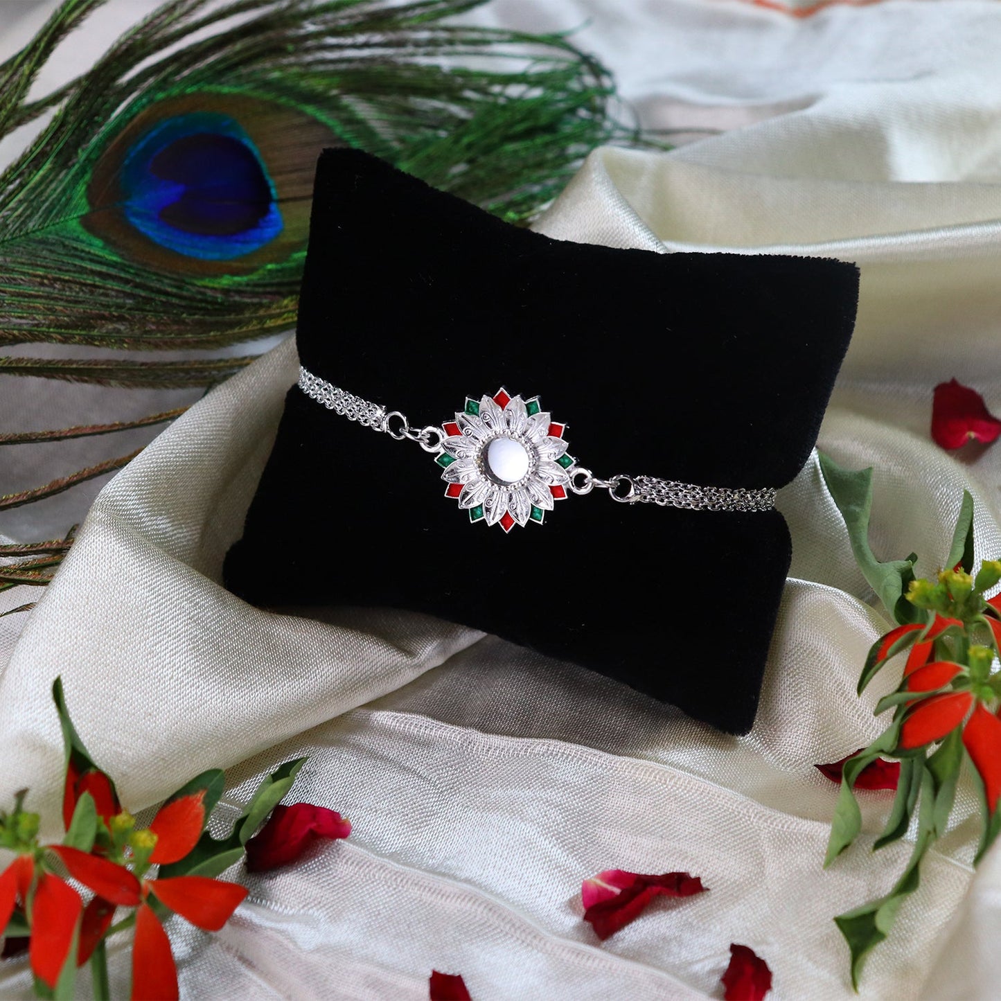 Close-up of elegant Silver Rakhi with Meenakari work, tied on a brother's wrist.