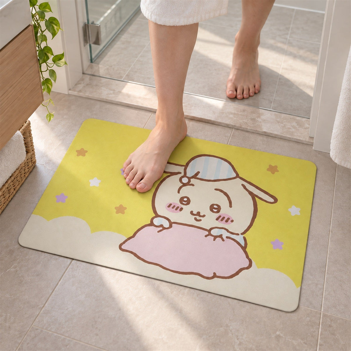 A person's bare feet step onto a yellow bath mat with a cute cartoon bunny wearing a striped nightcap.