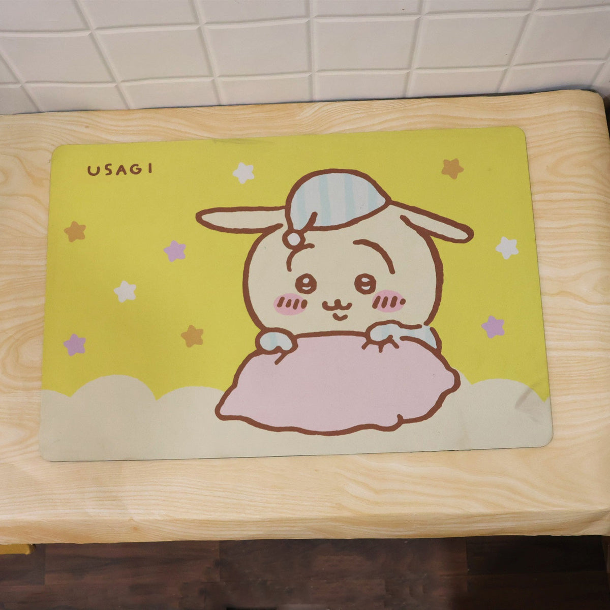 The yellow bath mat, featuring a cartoon bunny, rests on a light wooden surface with the word "USAGI" printed.