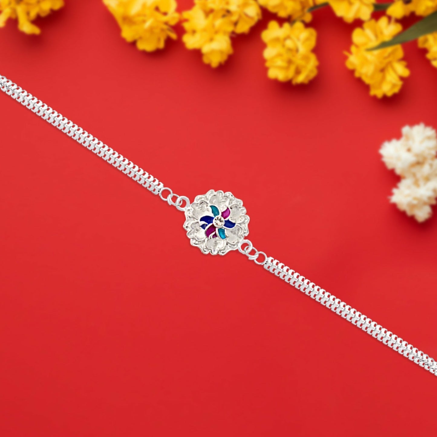 Close-up view of the silver floral Rakhi showcasing its intricate enamel work.