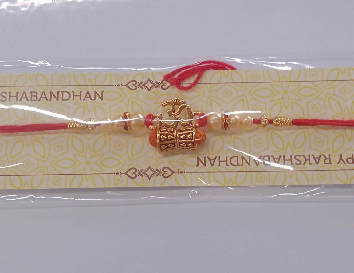 Detailed craftsmanship of the golden charm and pearl beads on this traditional Rakhi bracelet.