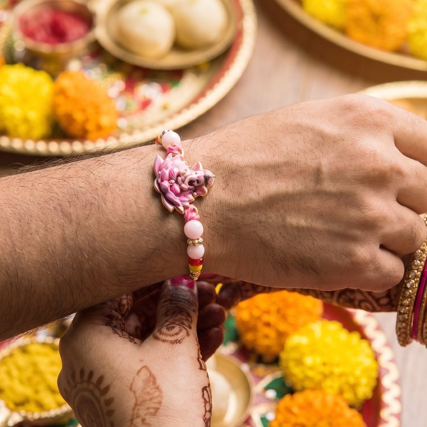 Close-up of Lord Ganesha centerpiece on pink lotus Rakhi