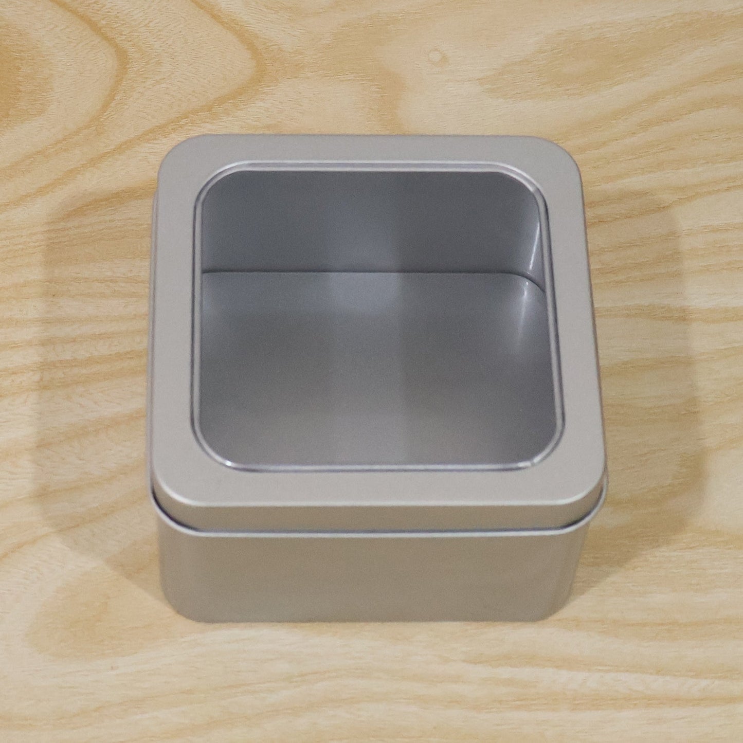 Detail shot of metal storage tin box, highlighting sturdy construction and clear lid