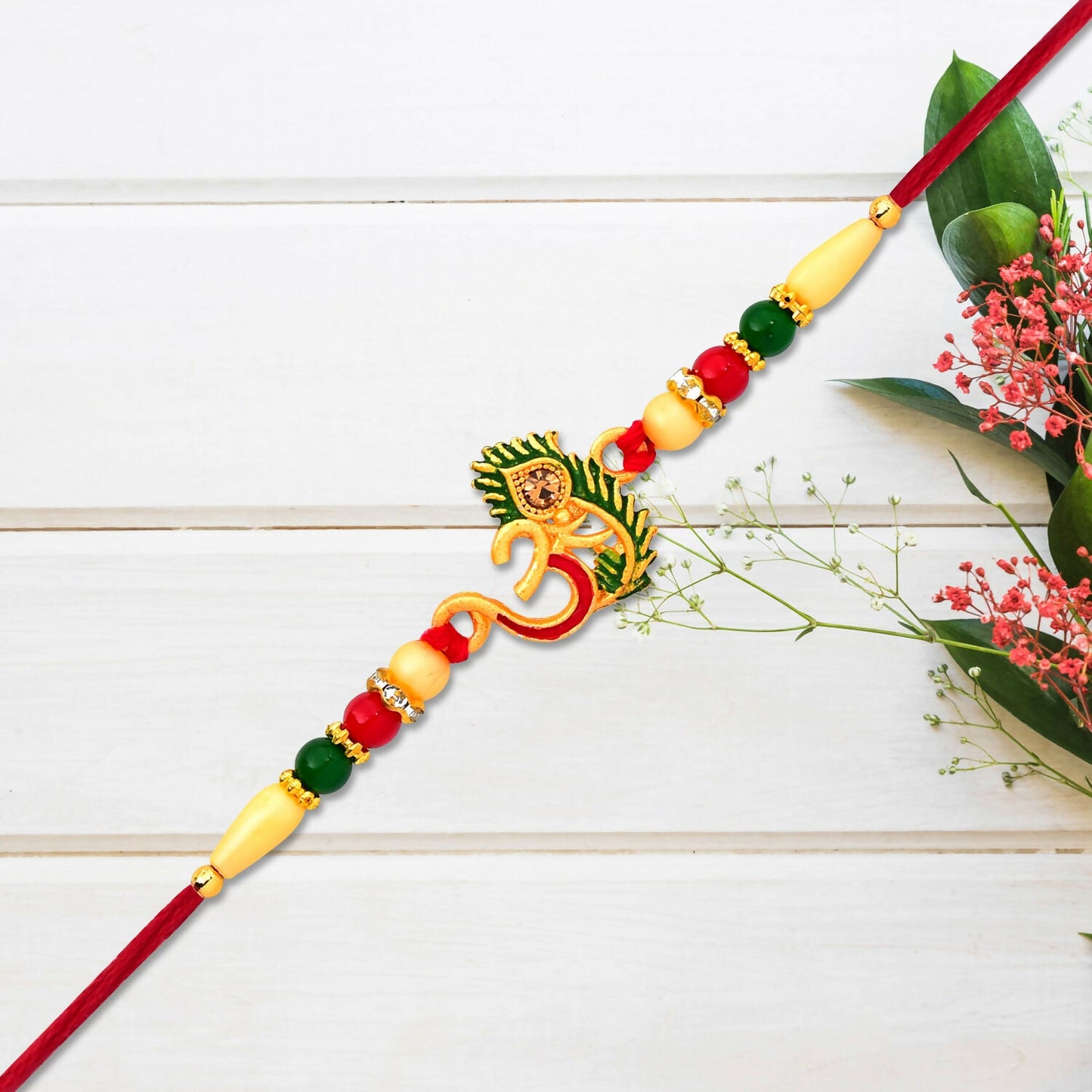 Close-up view of handcrafted Om symbol and peacock feather on Rakhi wristband
