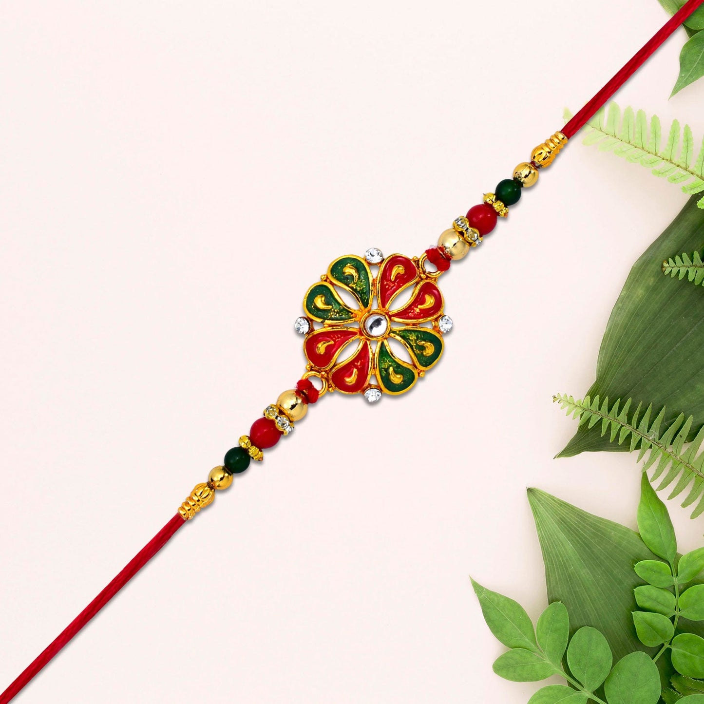 Close-up of the designer Flower Rakhi, showcasing intricate enamel work and golden bead details.