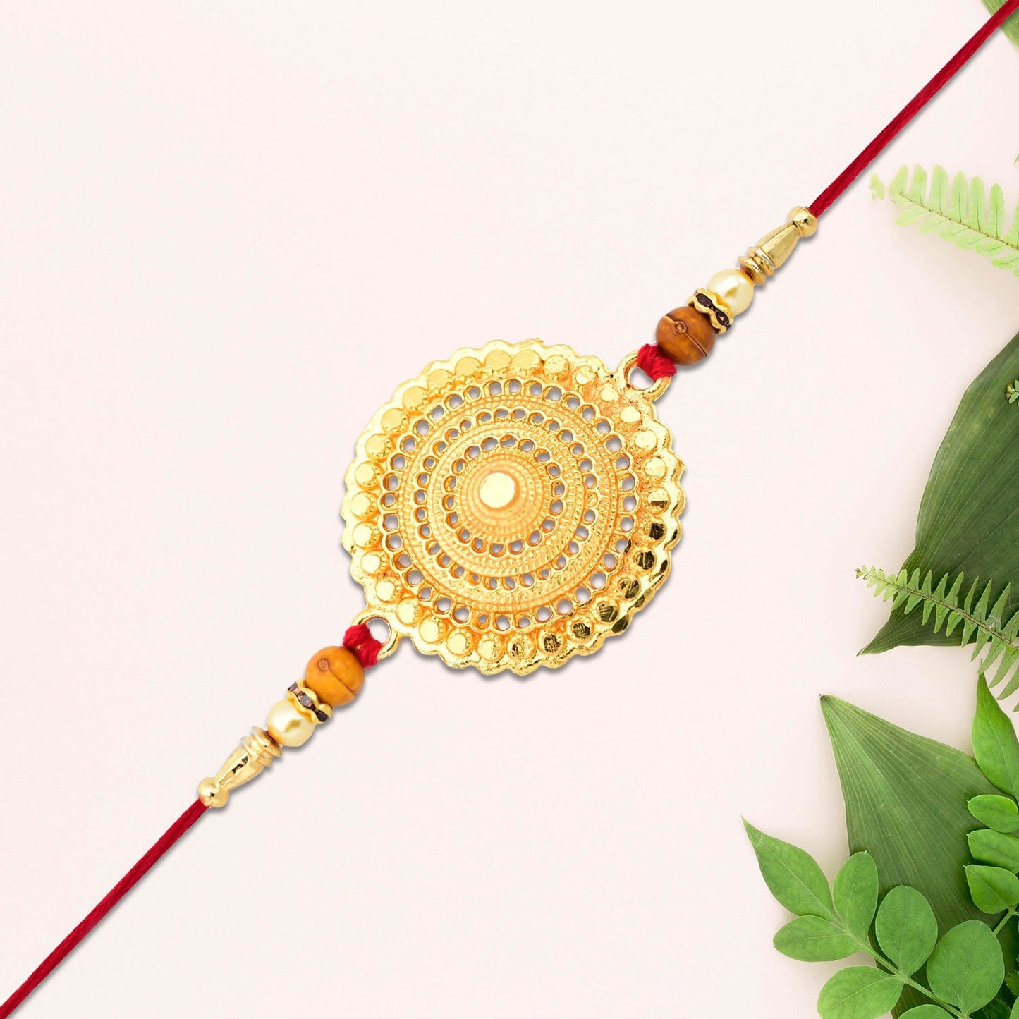 Decorative golden rakhi laid flat with beaded and elegant details