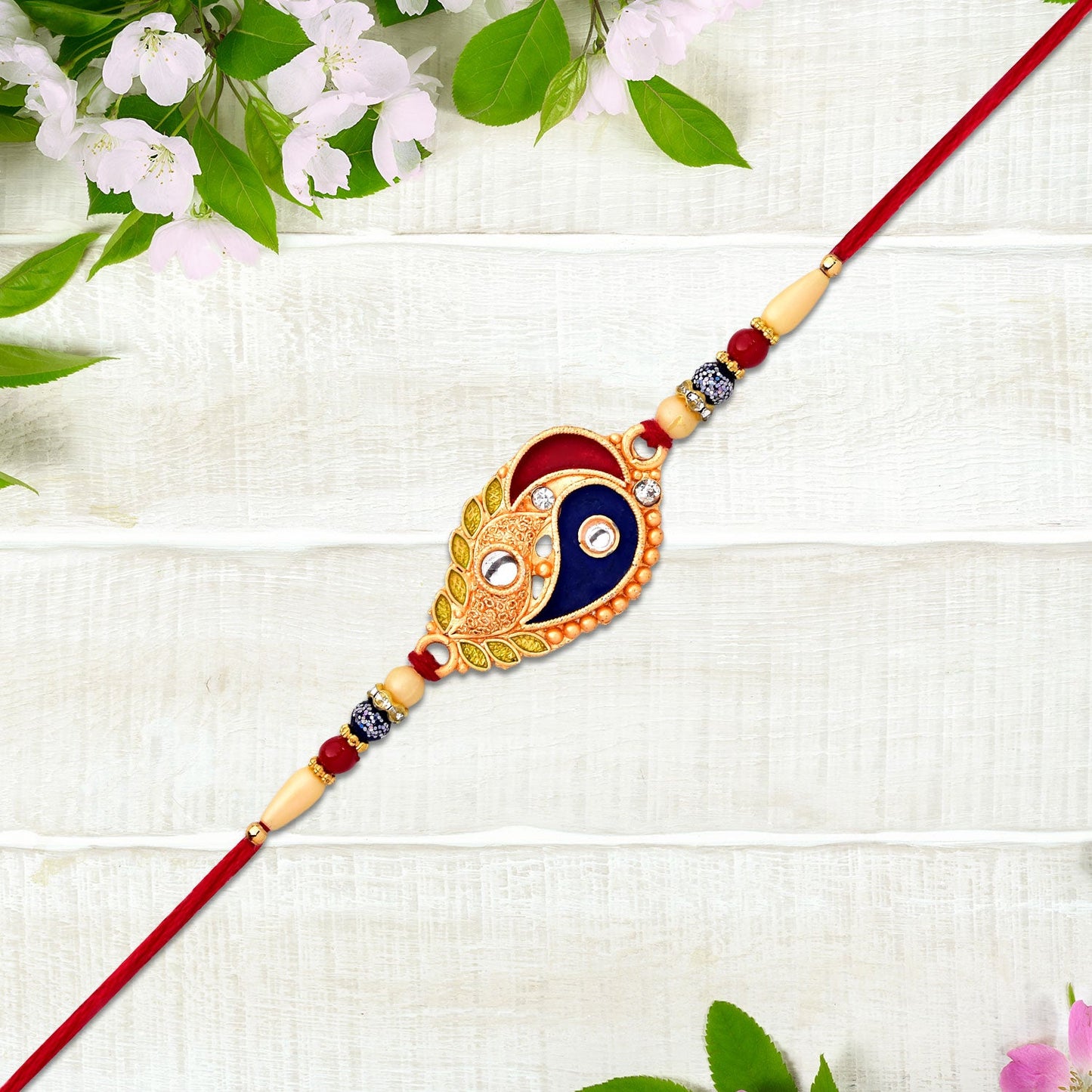 Close-up of enamel paisley rakhi showing gold-tone accents and artistic craftsmanship