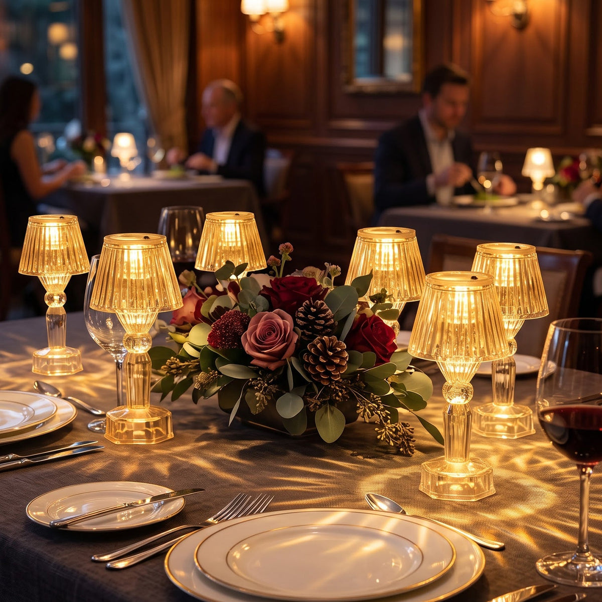 A luxurious restaurant setting with multiple clear acrylic LED lamps casting light patterns on a dark tablecloth.