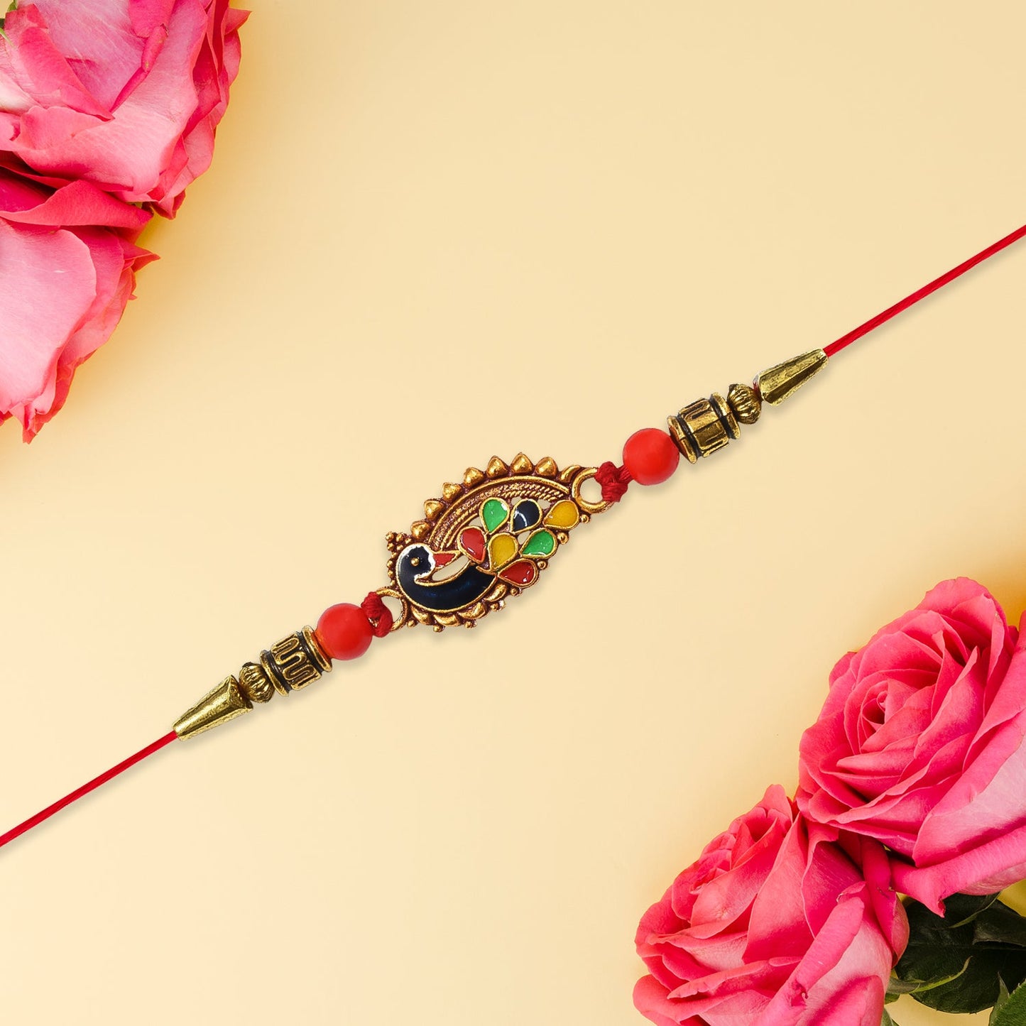 Close-up view of intricate peacock design on the designer Rakhi thread with red beads.