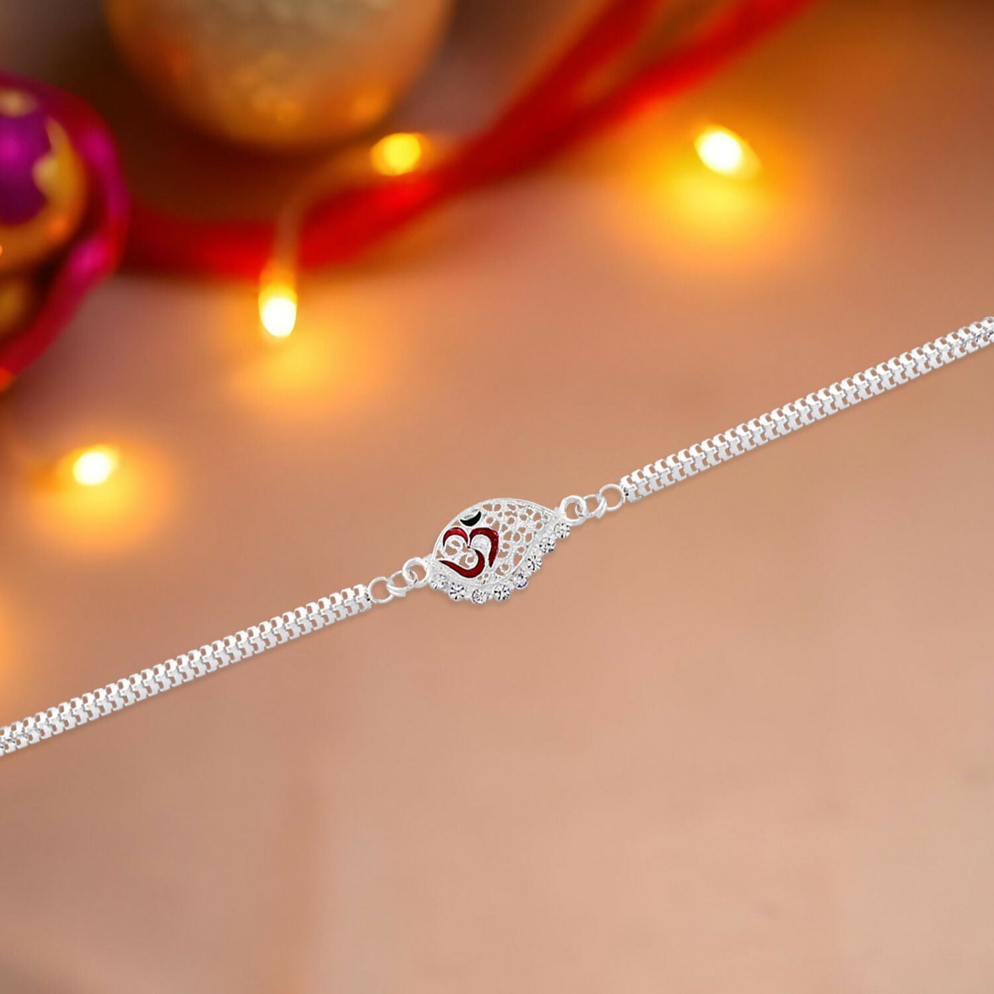 Close-up of designer silver plated Rakhi highlighting Om symbol and intricate dual chain