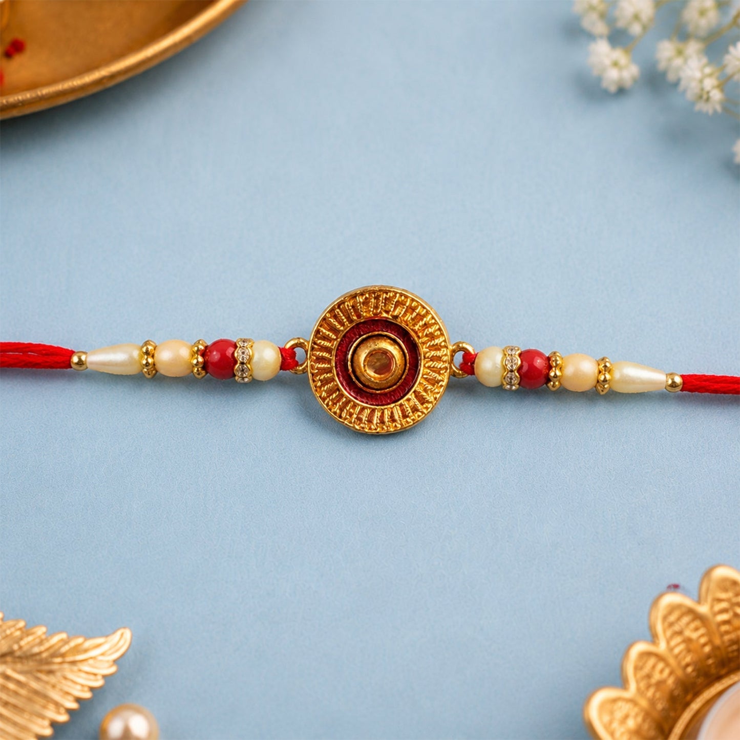 Traditional round rakhi adorned with pearl beads showcasing elegant festive design.