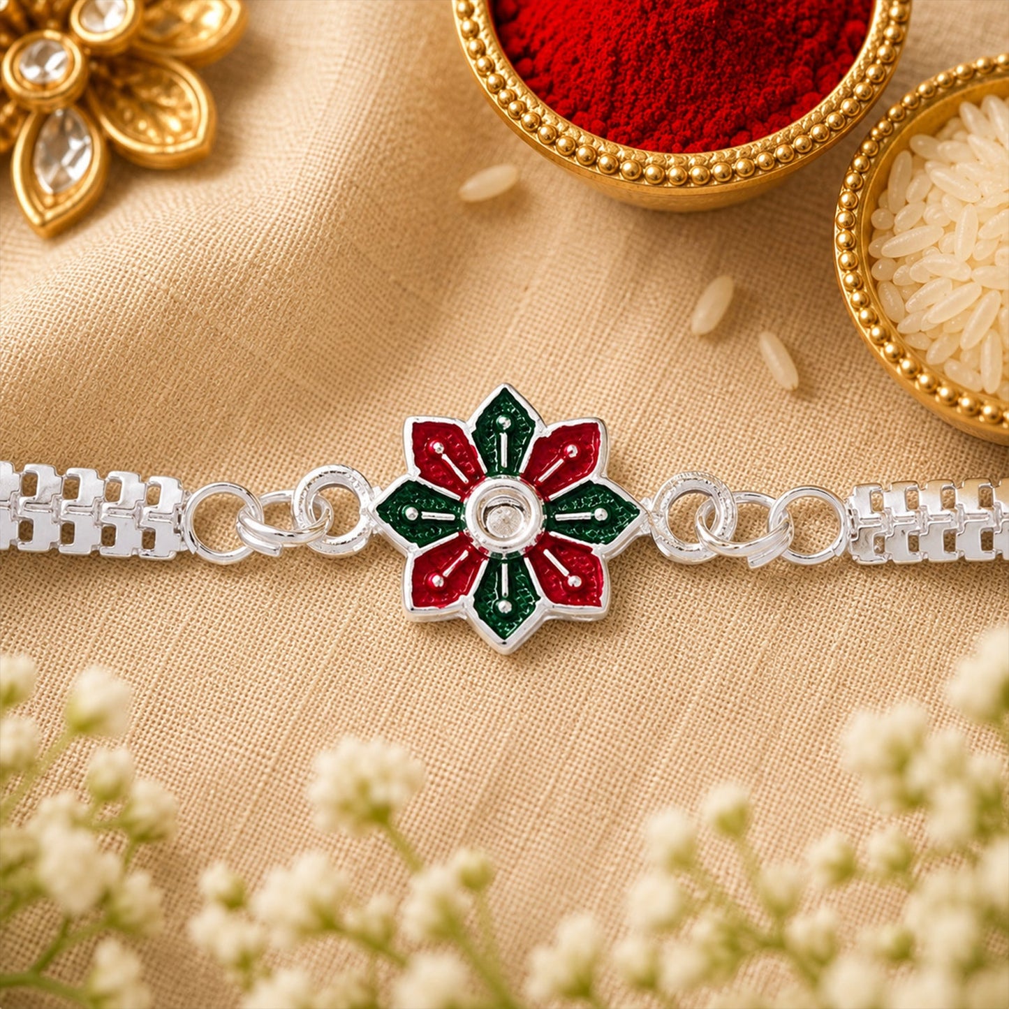 Close-up of a Star Floral Silver Rakhi with red and green enamel detailing.