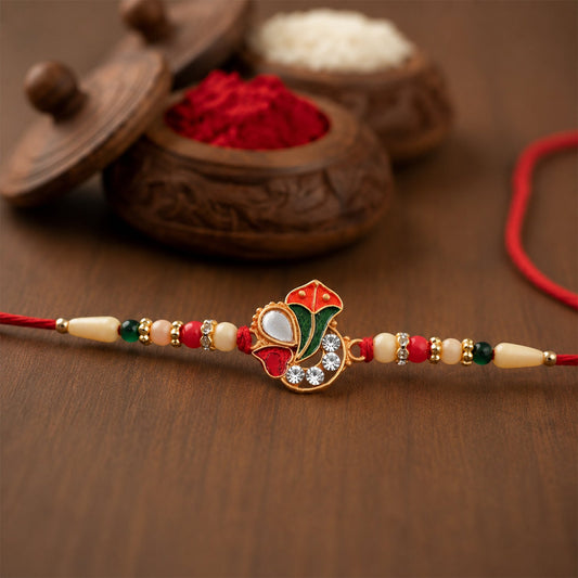 Ganpati Rakhi with intricate enamel work and traditional beads on vibrant thread