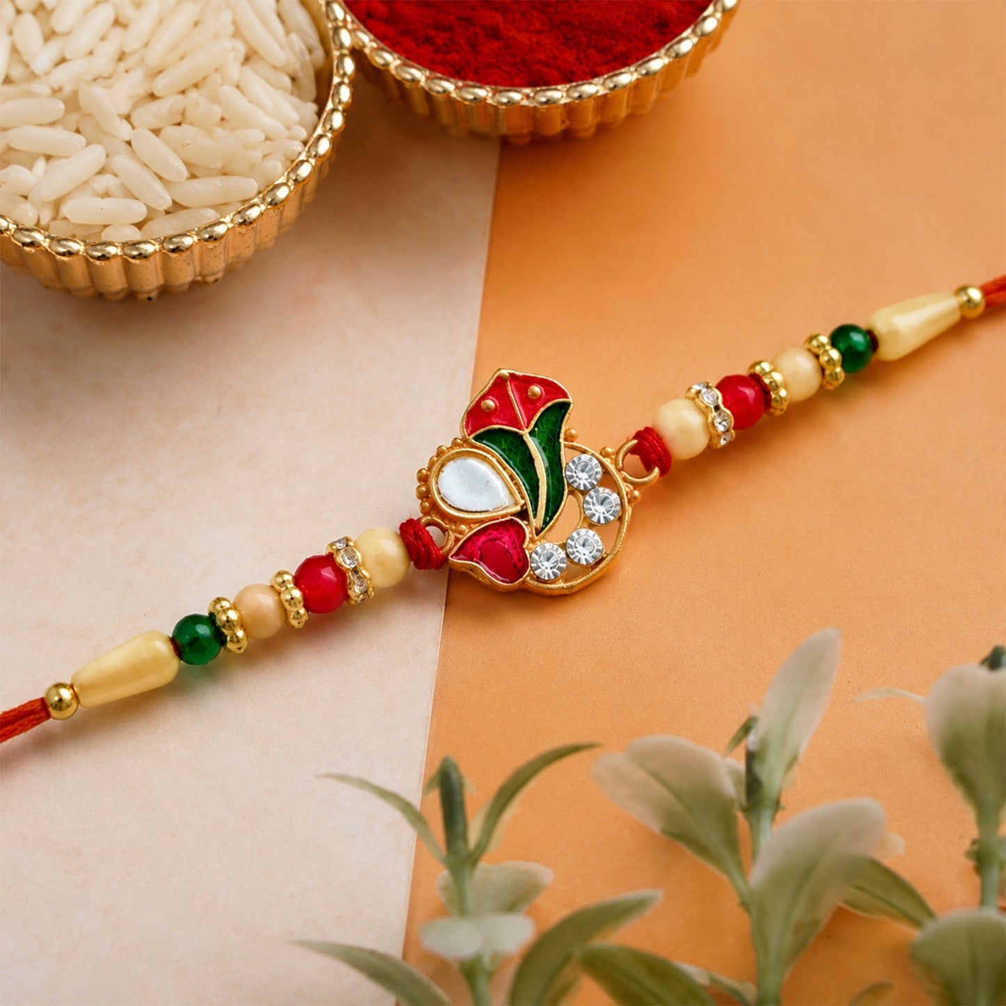 Close-up of Ganpati Rakhi showcasing colorful enamel Ganpati motif and hand-strung beads