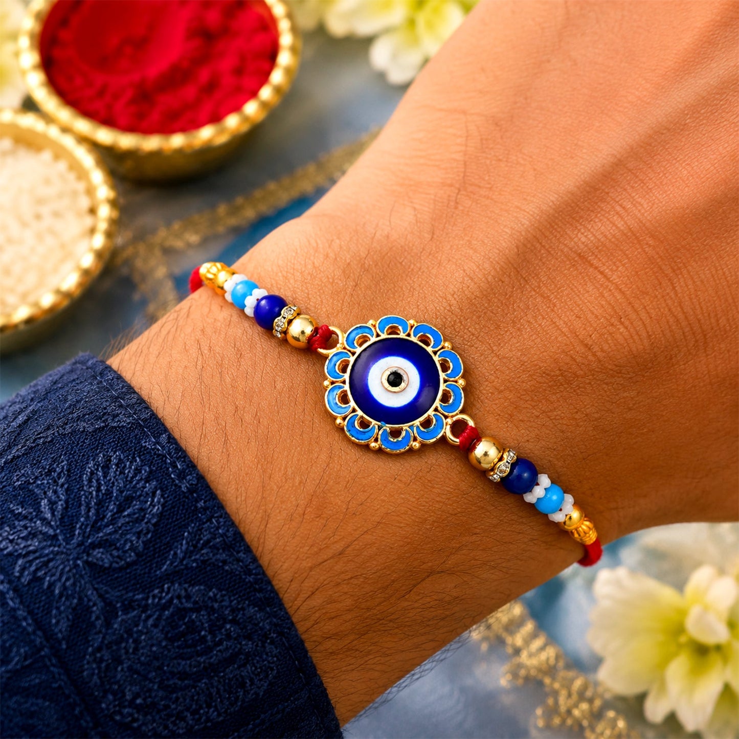Detailed view of the Evil Eye Rakhi showcasing its intricate blue beads and golden embellishments.