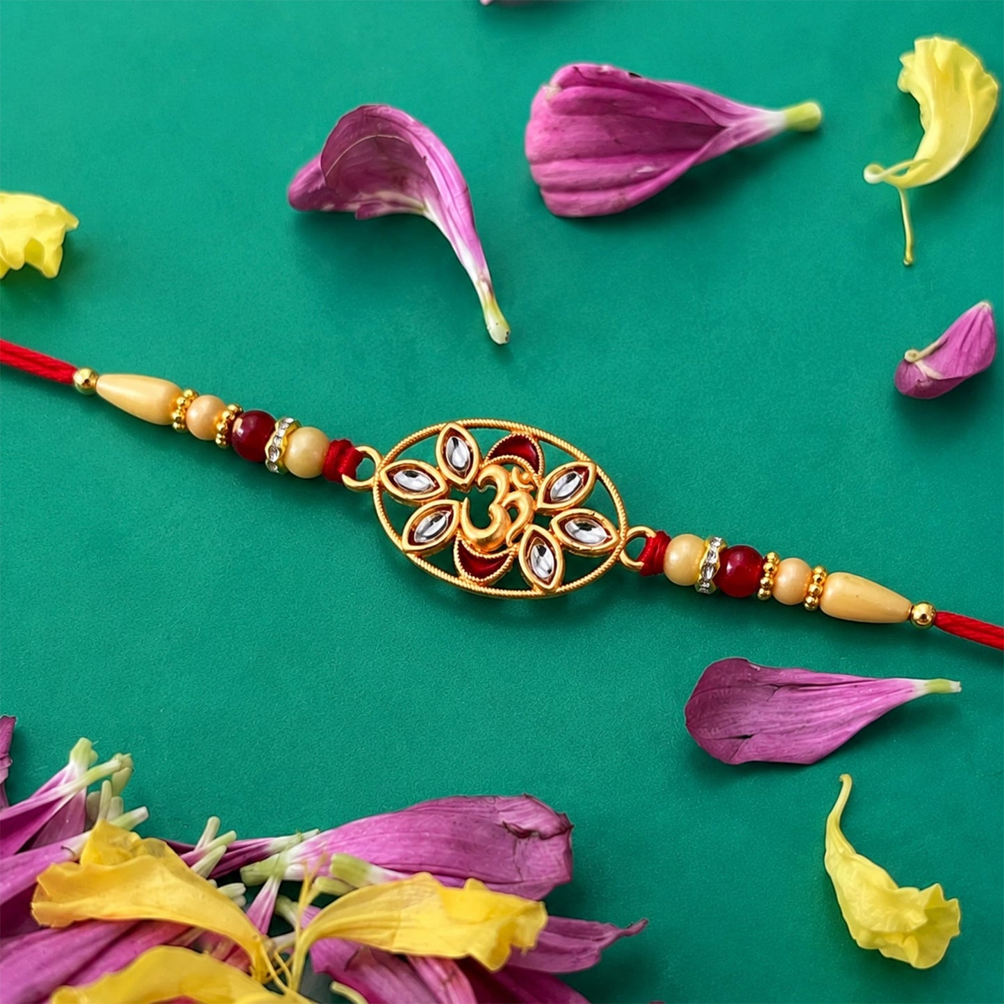 Elegant Om Kundan Rakhi with pearl beads displayed alongside a traditional puja thali.