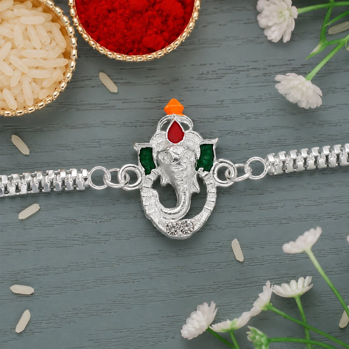Close-up of the intricate Ganesha motif with colourful enamel work on the Rakhi thread.