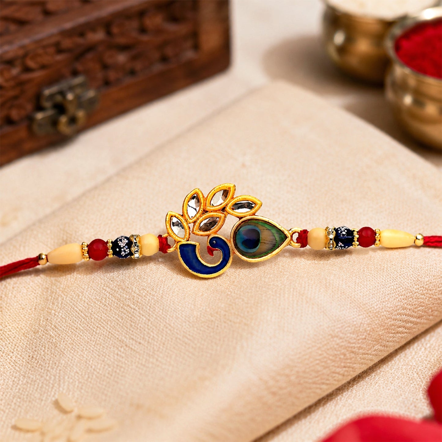 Side angle of Mor Pankh Rakhi showing intricate enamel work and traditional thread
