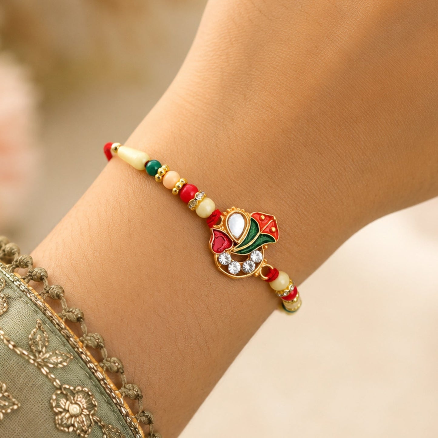 Elegant Ganpati Rakhi with traditional beads and shiny enamel work for brother's festive wear