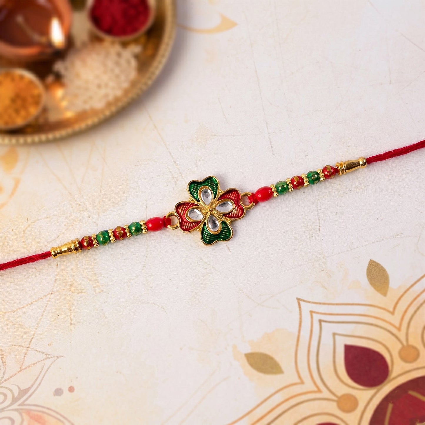 Traditional floral rakhi with decorative stones and multicolor beads