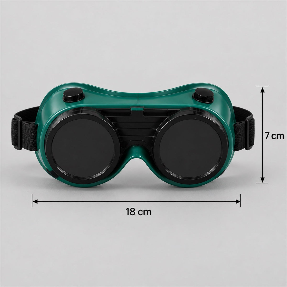 Green welding goggles with dark lenses and a black strap, showing dimensions of 18 cm width and 7 cm height.