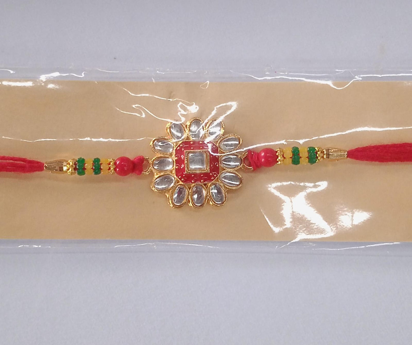 Detailed close-up of flower design Traditional Rakhi highlighting delicate stones and beads.