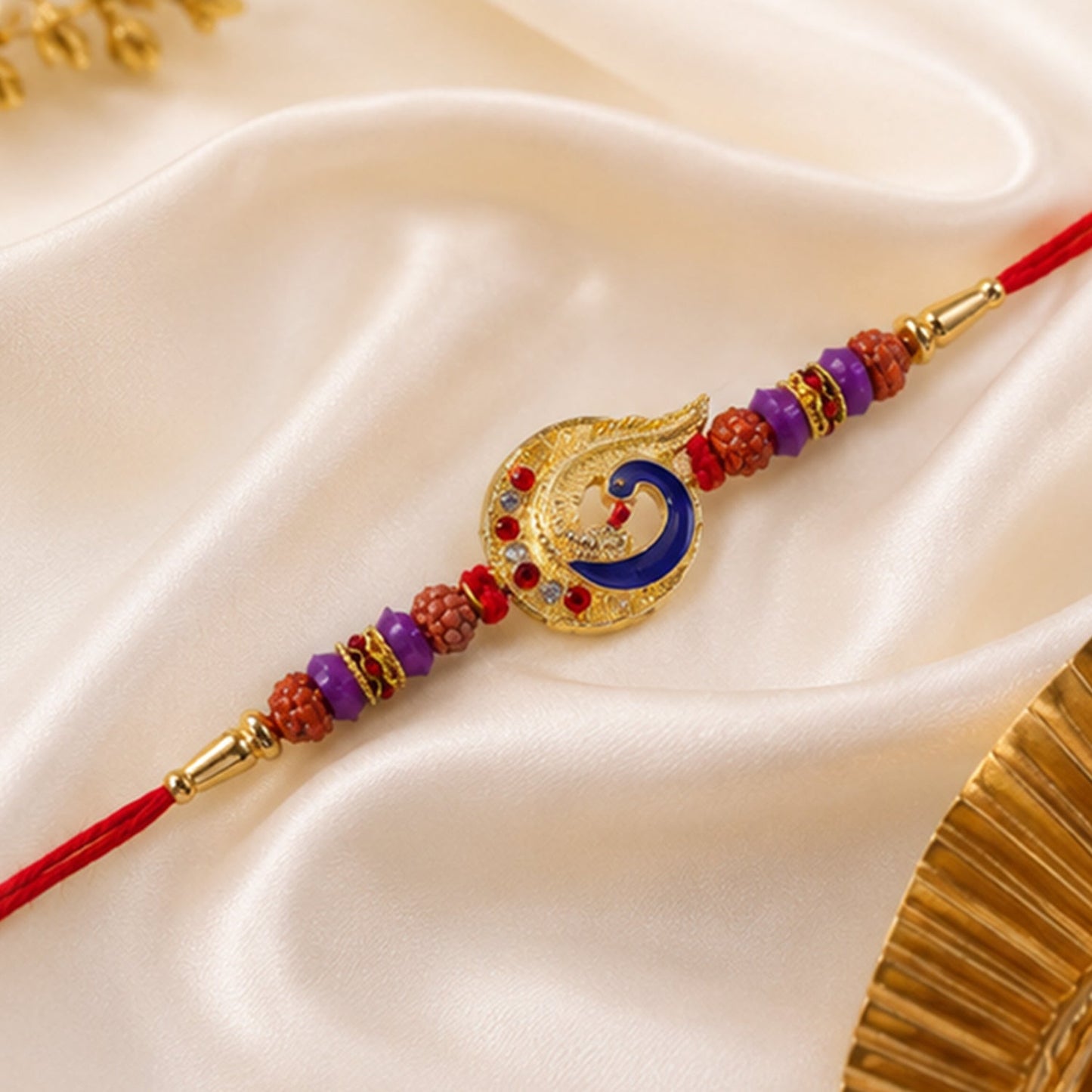 Close-up of designer Rakhi showing peacock motif and purple bead detailing.