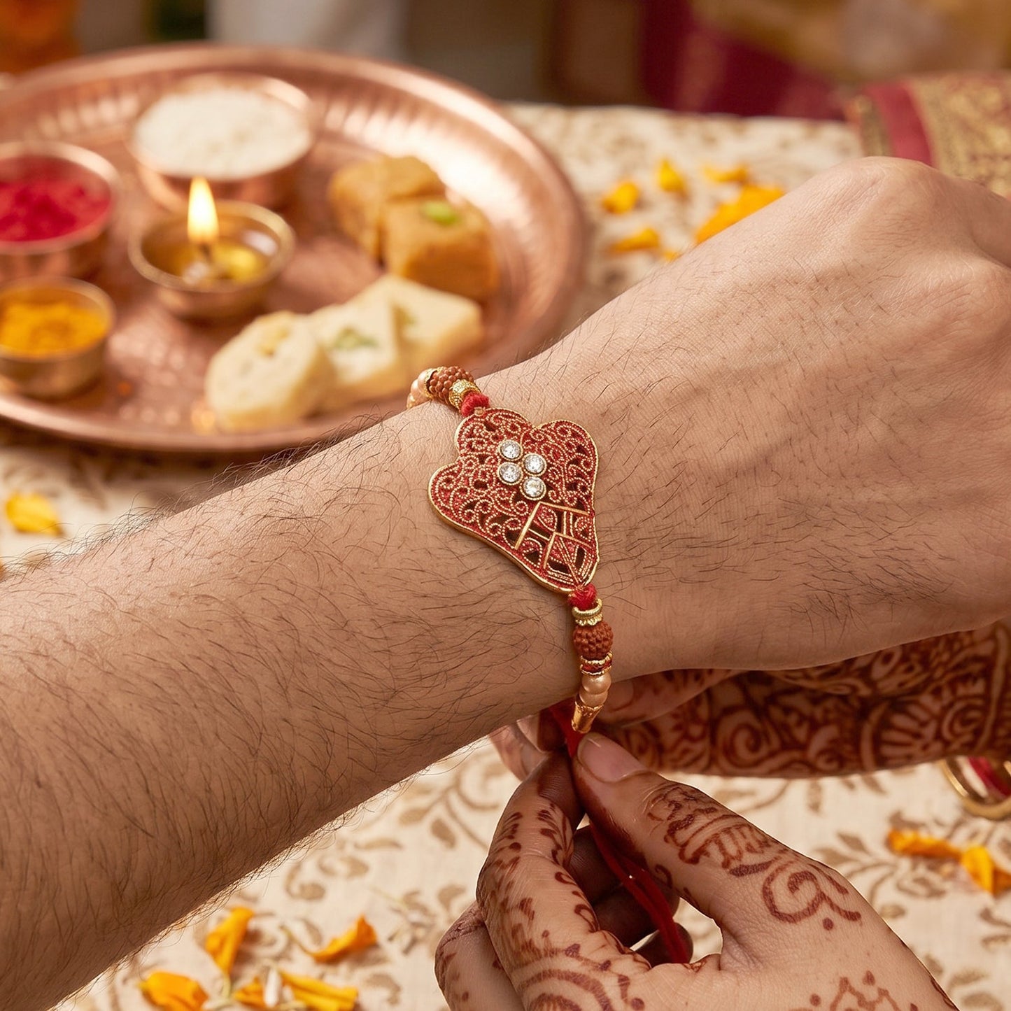 Red Heart Meenakari Rakhi with pearl chain and gold beads on white background