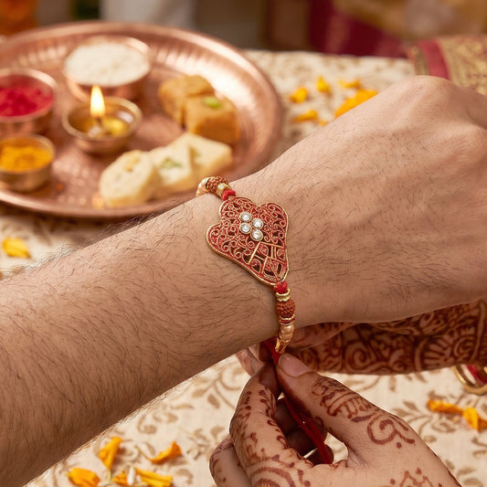 Red Heart Meenakari Rakhi with pearl chain and gold beads on white background