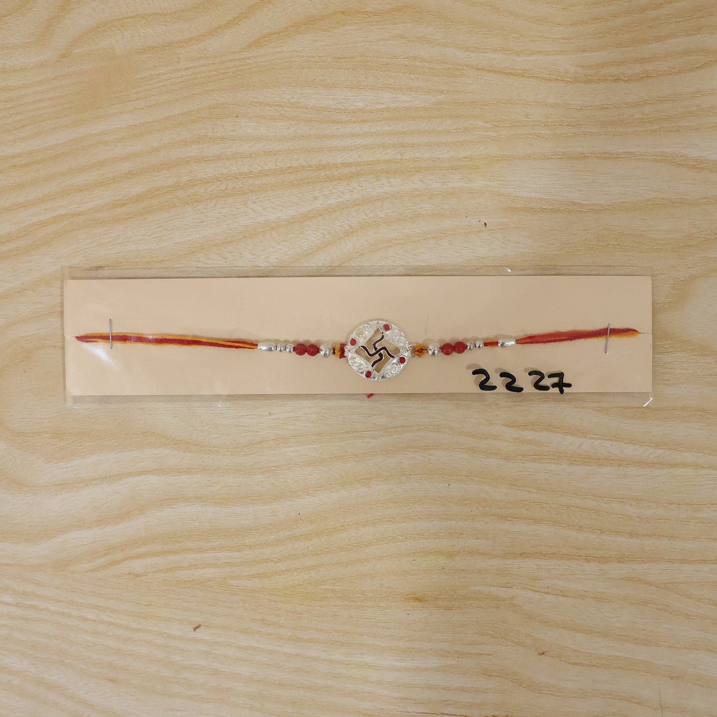 Festive rakhi with detailed finishing and red thread