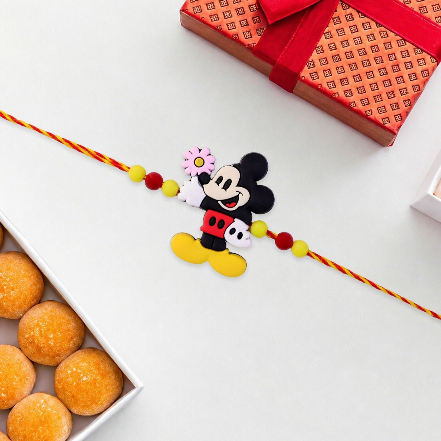 Detailed shot of the colorful beads and secure thread of the cartoon Rakhi.