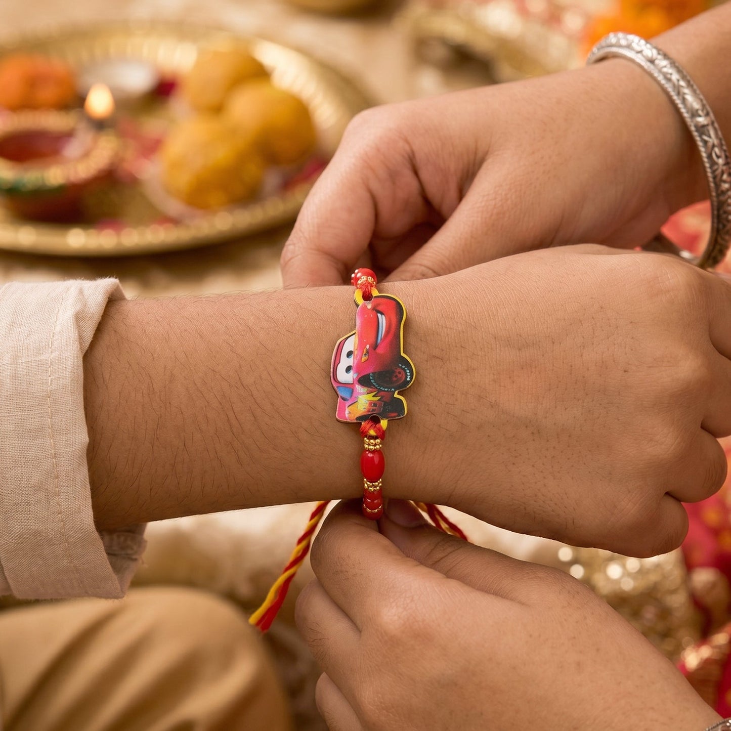 Side view showing intricate gold bead work on the Kids Racing Car Rakhi.