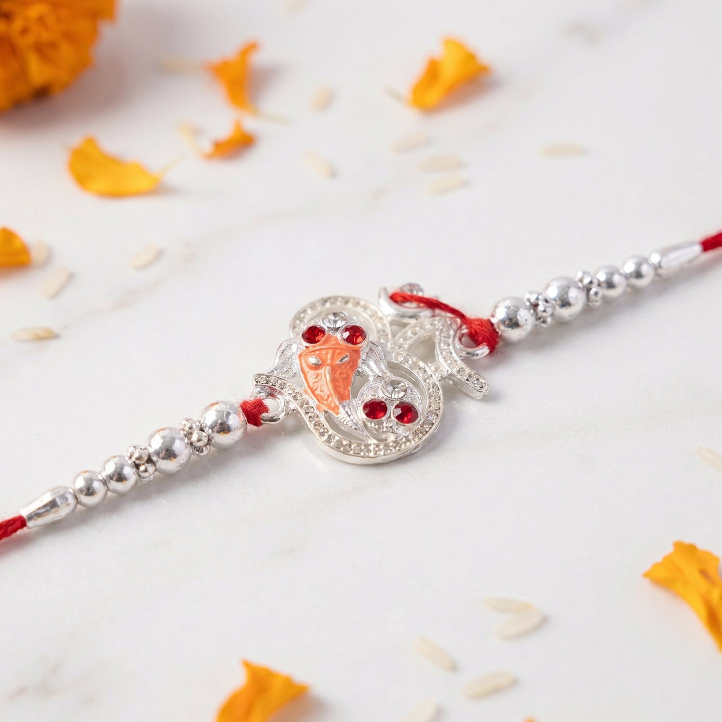 Silver Om Ganesh Rakhi displayed on hand wrist