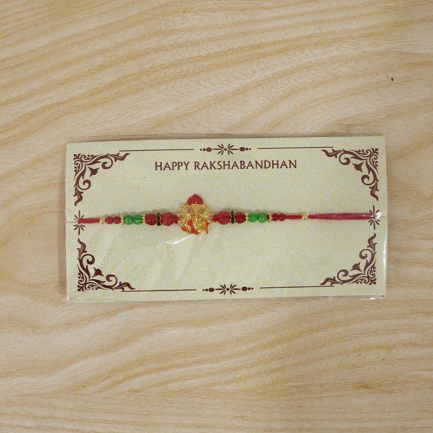 Antique-style golden Ganesha Rakhi with beads and intricate design