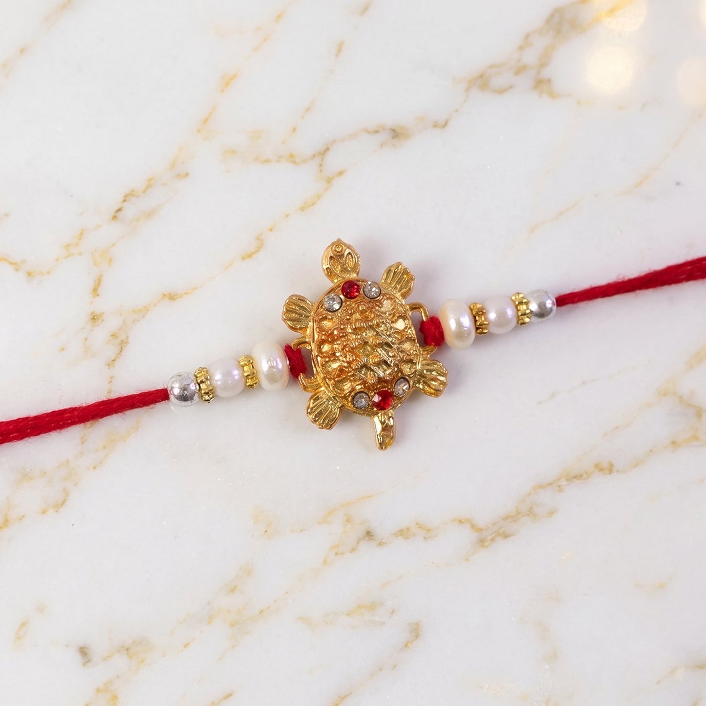 Back detail of the red mauli thread on Turtle Rakhi.