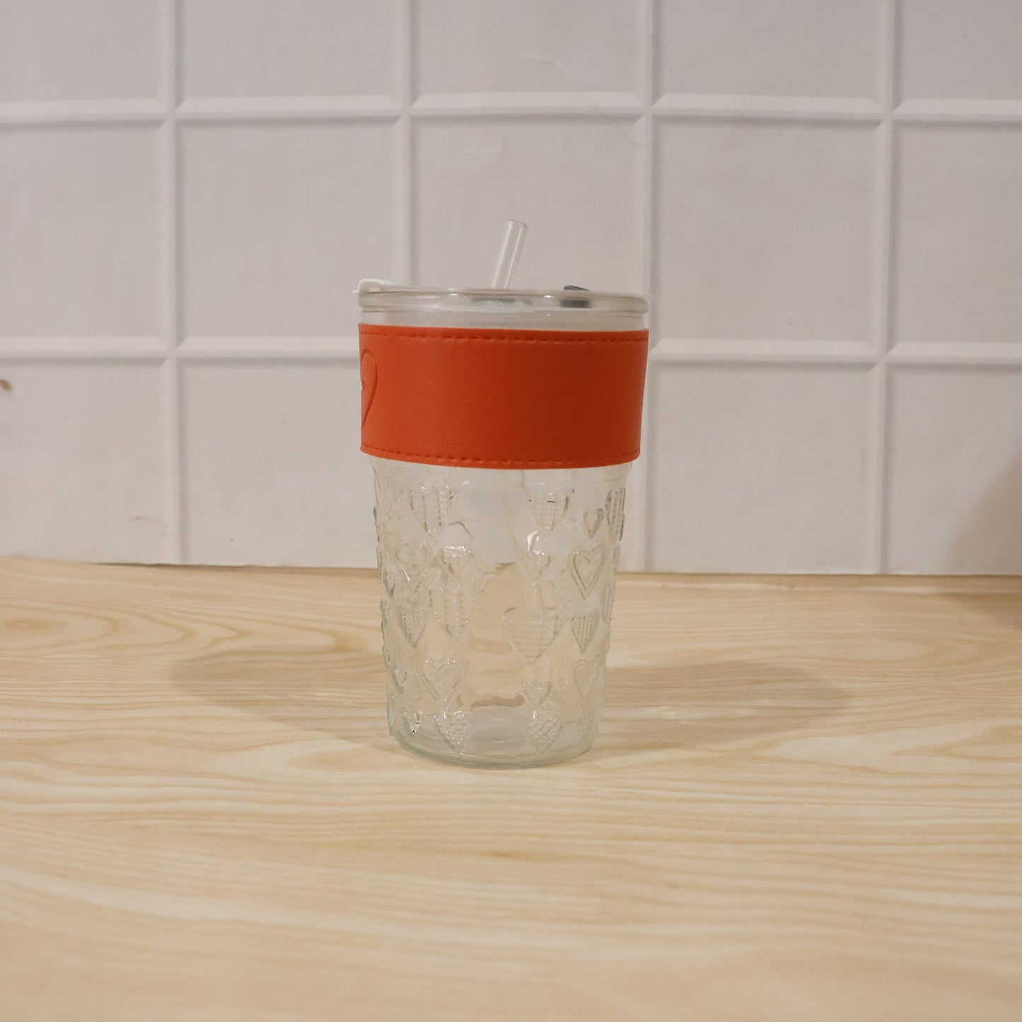Hand holding glass tumbler with lid, ready for daily use