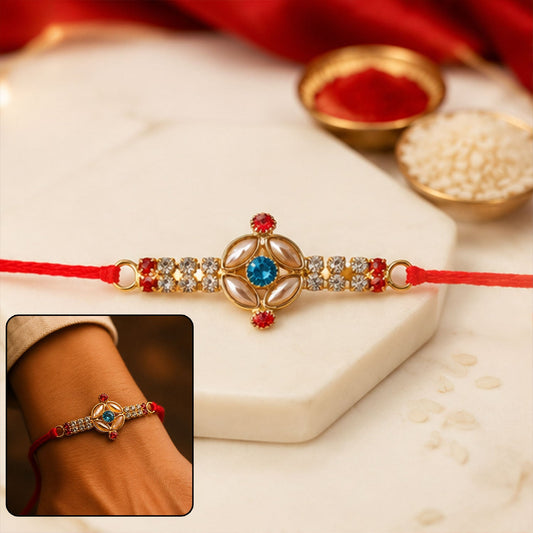 Blue floral Kundan Rakhi with red stones and pearl ends front view