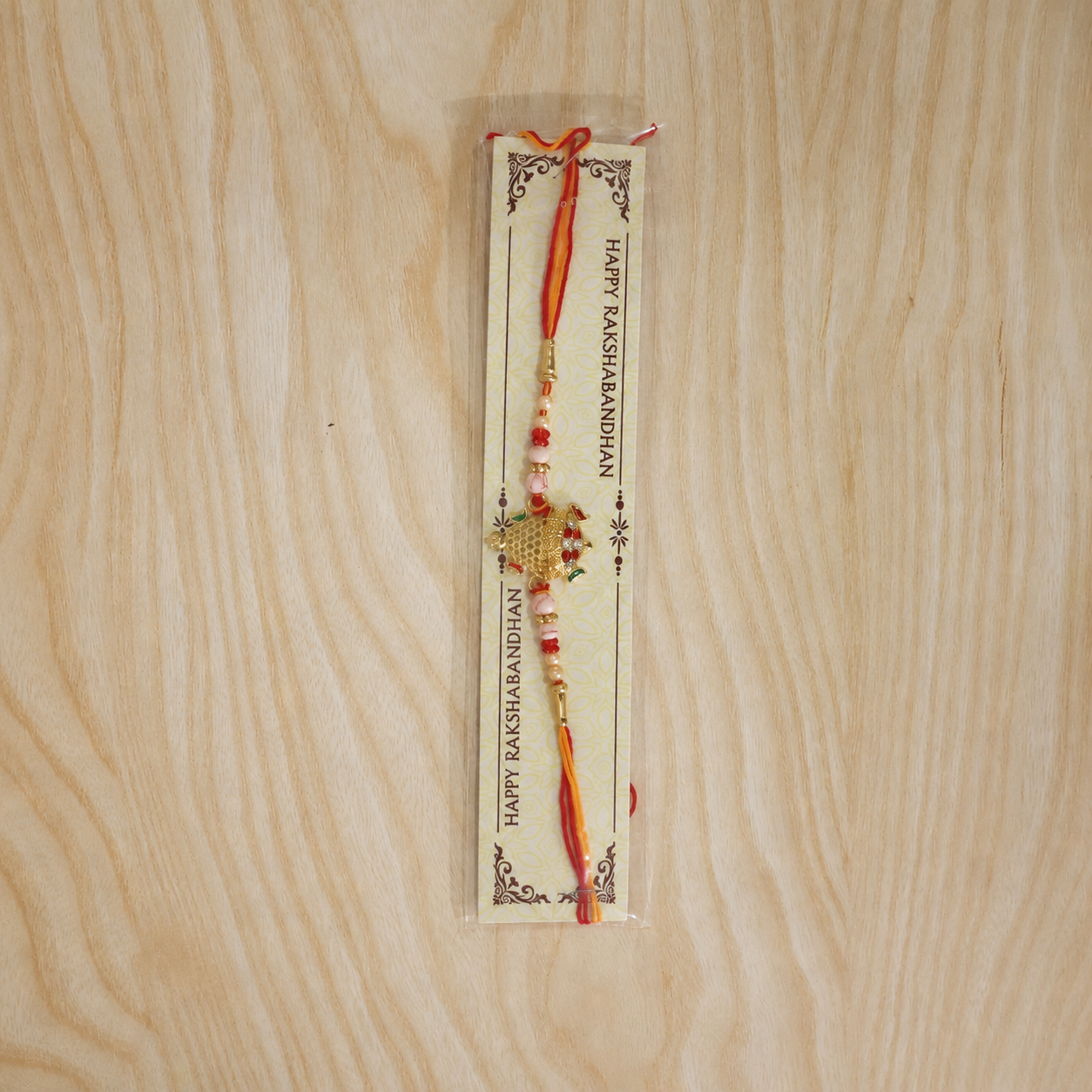Elegant Gold Turtle Rakhi with vibrant red thread