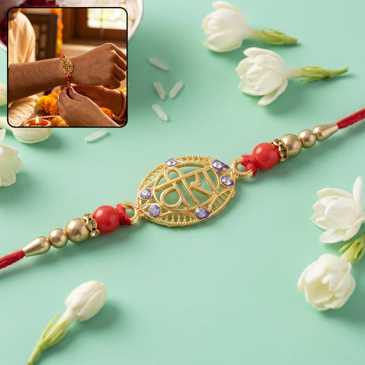 Golden Veera Rakhi with red beads and elegant thread close-up