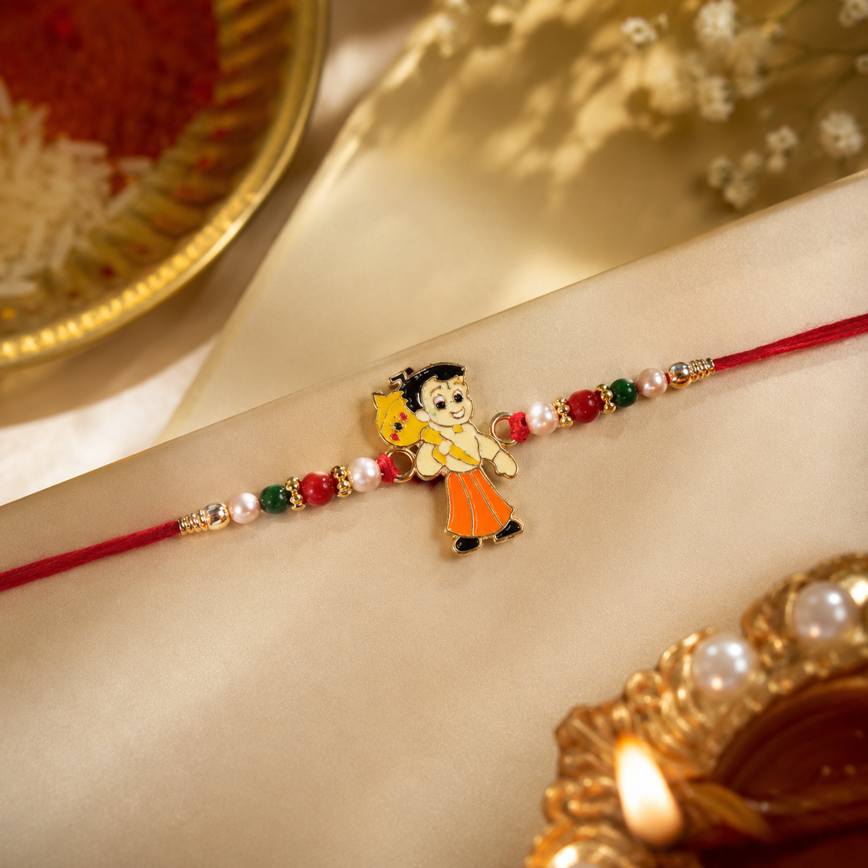 Close-up of the charming cartoon boy centerpiece on this fun rakhi design.