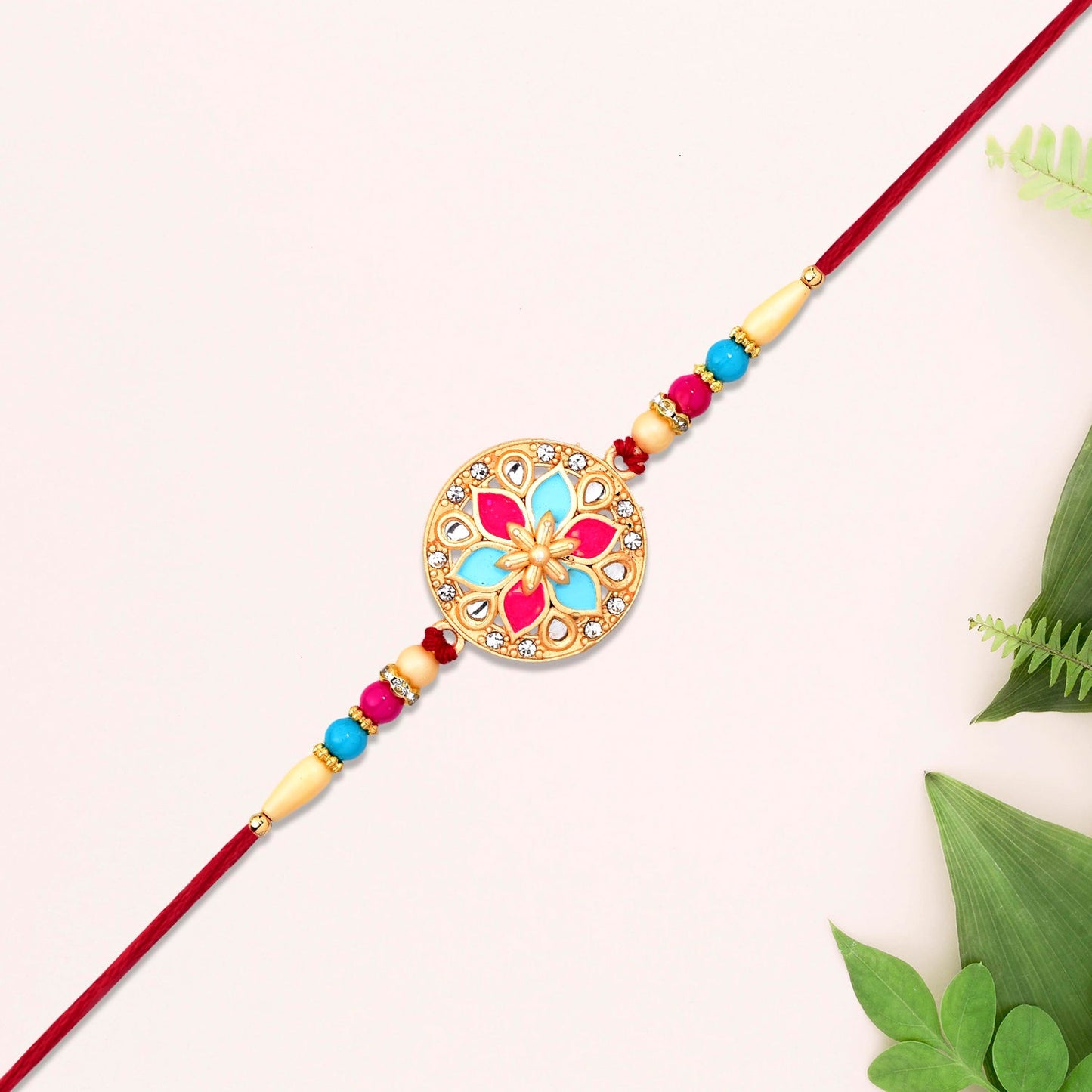 Elegant round floral rakhi featuring colorful pink blue enamel and skin-friendly beaded thread